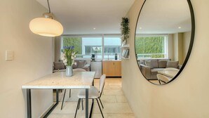 A modern kitchen with a dining area, a large mirror, and a view of the outdoors. - Modern King Studio in Central Roma Norte (Ciudad de México)