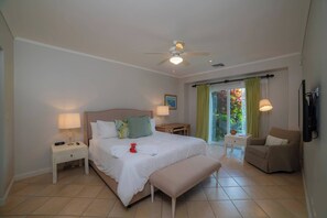 A bedroom with a bed, bedside table, lamp, bench, chair, and a ceiling fan. - Del Mar 4N - 3 bdr 2 bath Family (Playa Herradura)