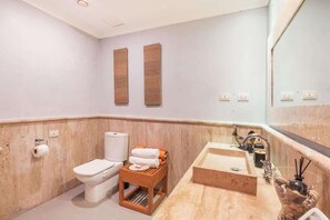 Ein Badezimmer mit Toilette, Waschbecken und Spiegel.