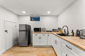 A modern kitchen with a stainless steel refrigerator, microwave, and toaster. - Modern Arvada Hotspot Sauna & Games (Arvada)