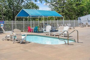 A swimming pool with lounge chairs and a covered seating area. - The Canopy at Table Rock Lake (Kimberling City)