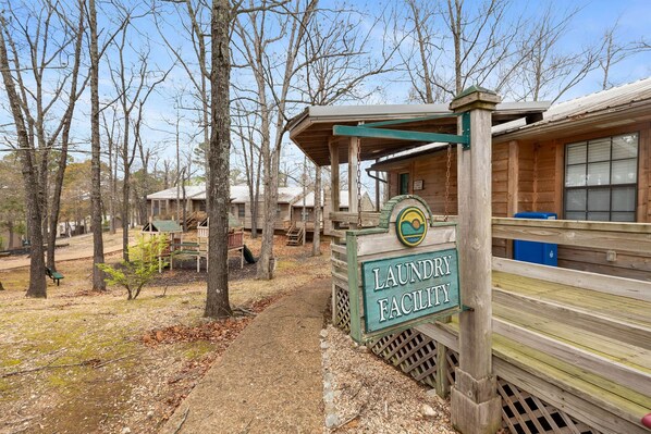 A wooden cabin with a sign for a laundry facility. - The Canopy at Table Rock Lake (Kimberling City)