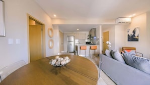 A modern kitchen with a refrigerator, stove, and bar stools. - Breakfast Included at Regatta Living 906 (Santo Domingo)