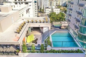 A rooftop pool area with a pool, lounge chairs, and potted plants. - Regatta Living Ii with Breakfast Included! - 502 (Santo Domingo)