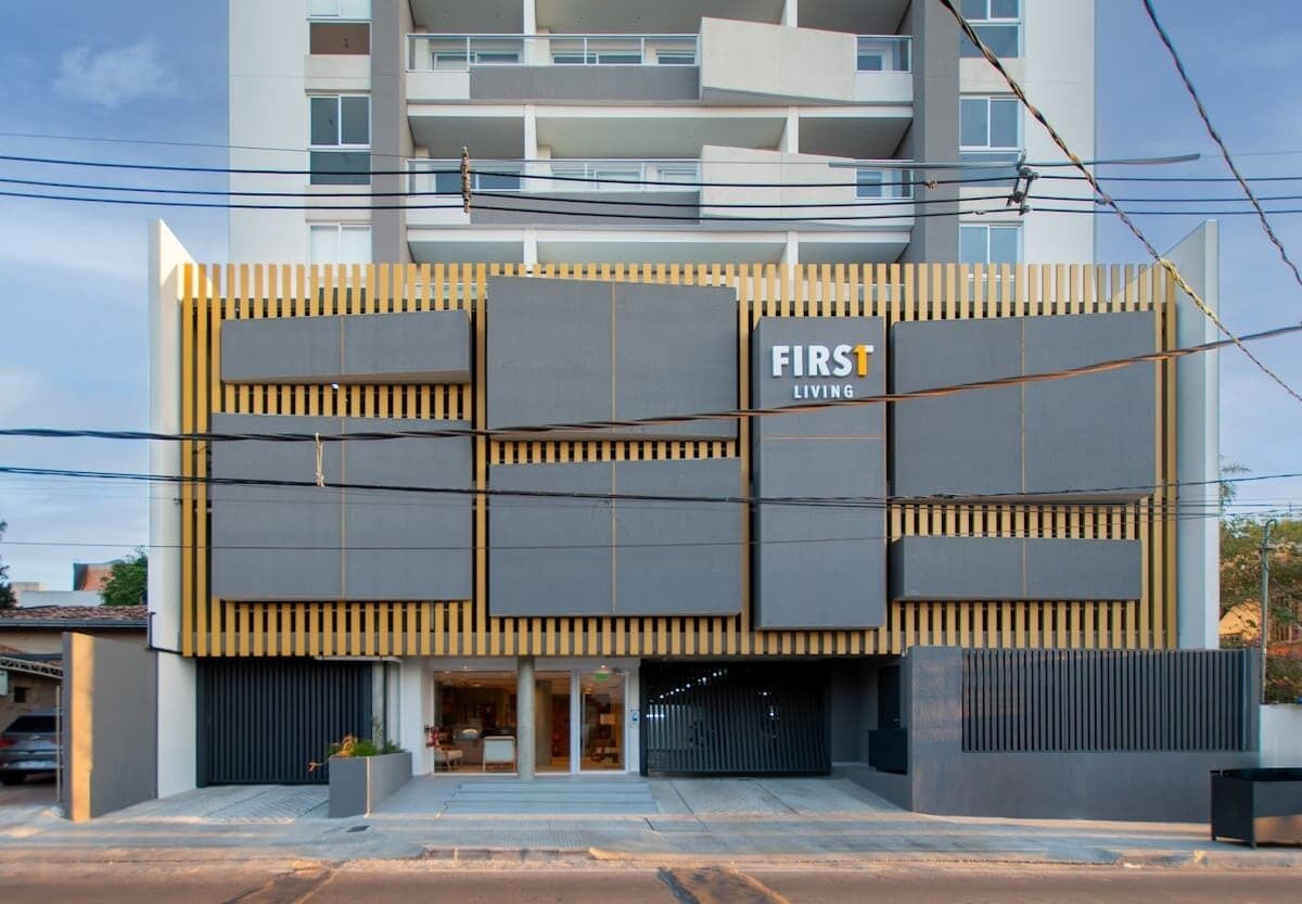 Un edificio moderno con un cartello che riporta la scritta 'FIRST LIVING'.