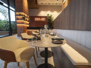 Un espace repas moderne avec une table ronde pouvant accueillir six personnes, entourée de sièges confortables.