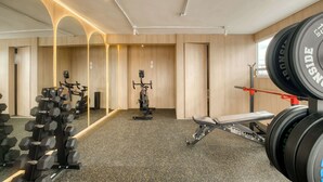 A gym with exercise equipment, a mirror, and a window. - Modern King Studio in Central Roma Norte (Ciudad de México)