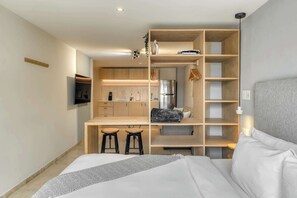A compact room with a bed, a kitchenette, and a small seating area. - Modern King Studio in Central Roma Norte (Ciudad de México)
