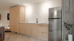 Uma cozinha moderna com armários de madeira, geladeira de aço inoxidável e design minimalista.