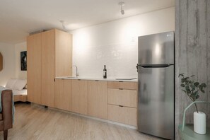Eine moderne Küche mit Holzschränken, einem Edelstahlkühlschrank und einem minimalistischen Design.