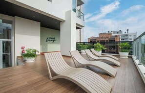 A rooftop terrace with lounge chairs, potted plants, and a sign reading 'TERRE lounge'. - High-Floor City Base 200Mbps Gym, Pool & Sauna (Asunción)