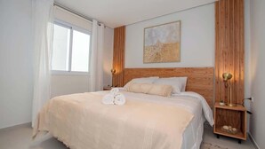 A bedroom with a large bed, a wooden headboard, a bedside table with a lamp, and a window with curtains. - Sleek 1BR Apt, City Views & Pool (Asunción)