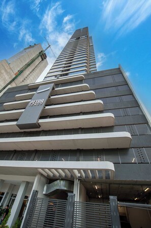 A high-rise building with a prominent 'Petra Towers' sign, large windows, and a modern architectural design. - Urban 1-Bedroom Escape in Petra Tower Asuncion (Asunción)