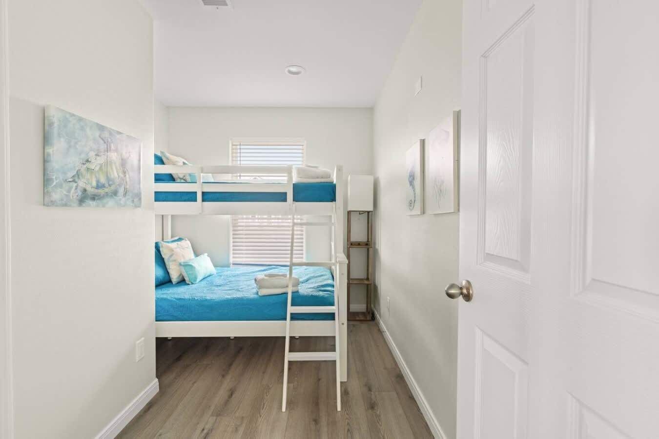 Una habitación con literas, una puerta y una ventana.
