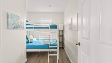 Una habitación con literas, una puerta y una ventana.