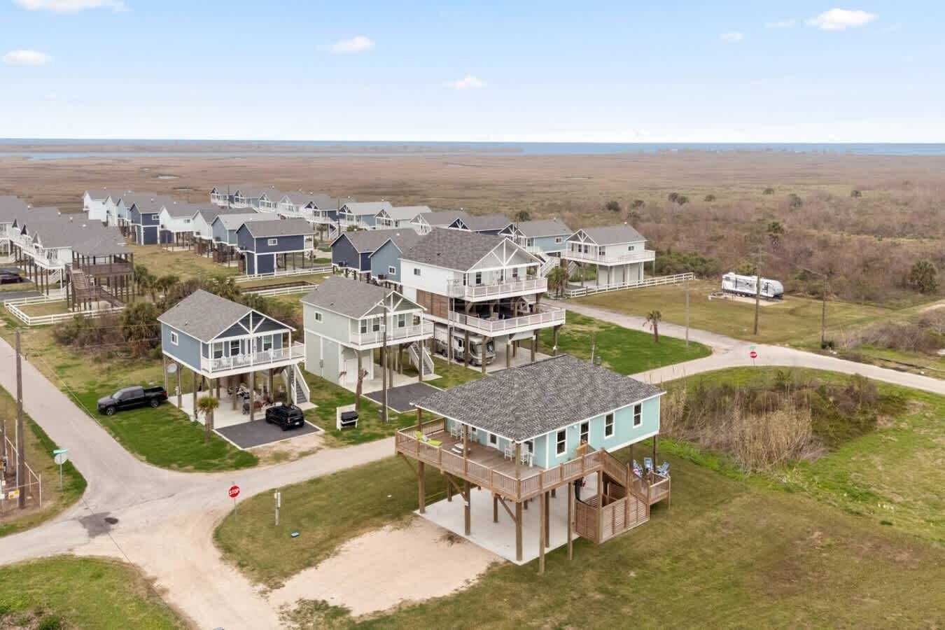 A coastal residential area with multiple two-story houses featuring balconies and waterfront access.