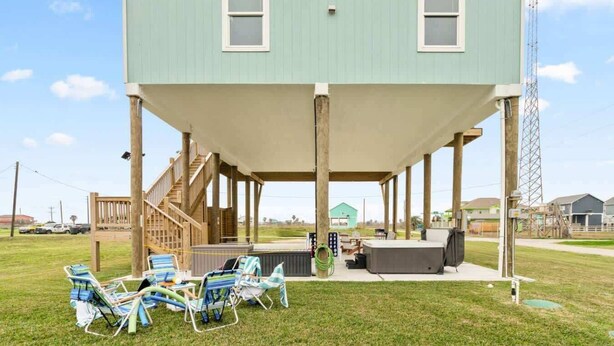A two-story house with a covered porch, outdoor seating area, and a pool. - Hot Tub, Pet Friendly, 4Bdr 2Bth, - Aqua Vista (Bolivar Peninsula)
