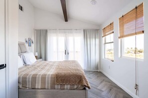 A bedroom with a bed, curtains, a window with a view, and a ceiling fan. - Unit C of Crystal Beach's Premier Triplex 2Bd 1Bth (Bolivar Peninsula)