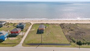 Zona residencial costera con casas, una playa y una carretera.