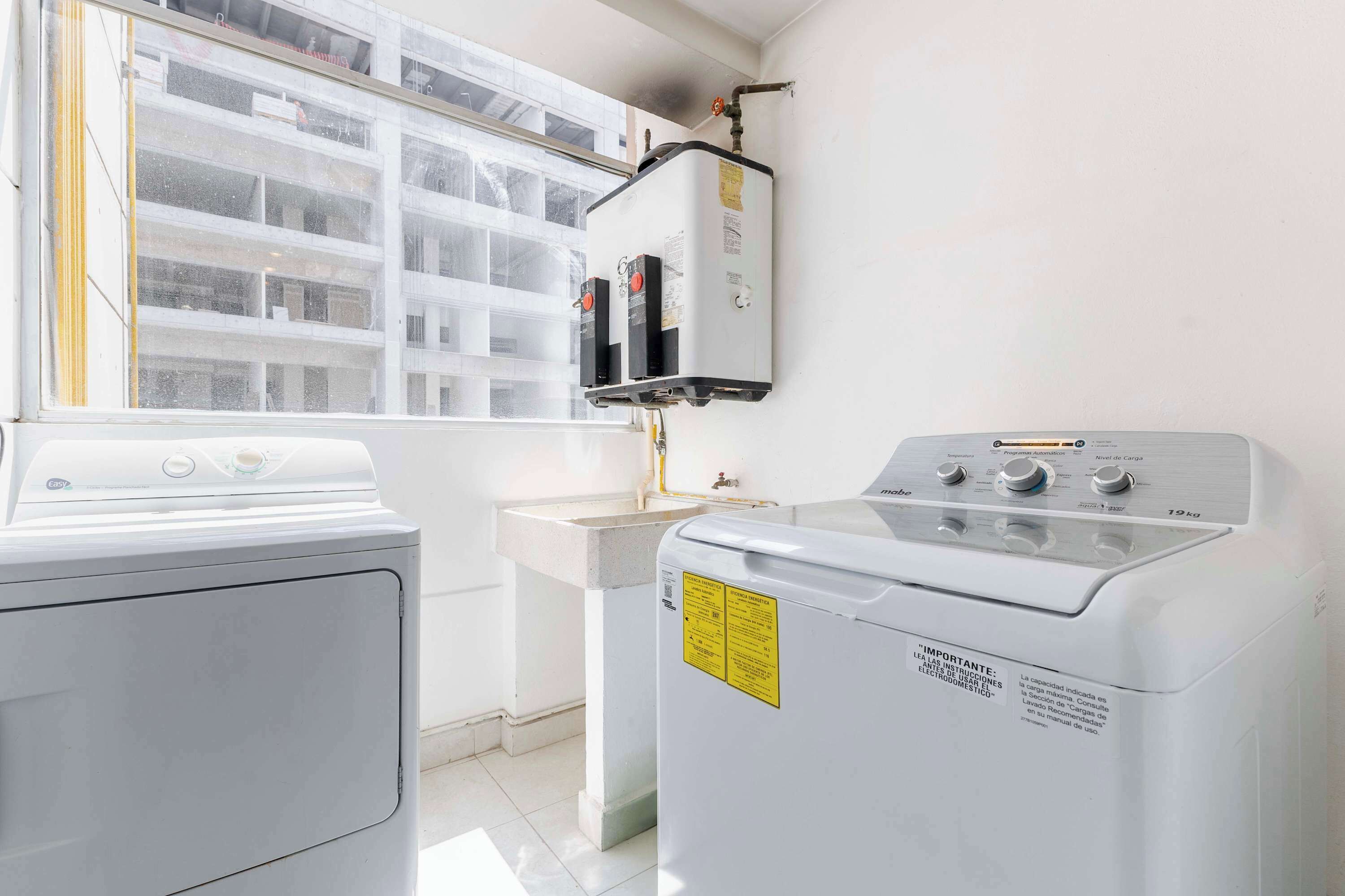 A laundry area with a washing machine, a dryer, and a water heater.