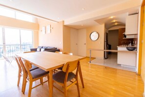 A modern living space with a dining area, a kitchen, and a balcony.