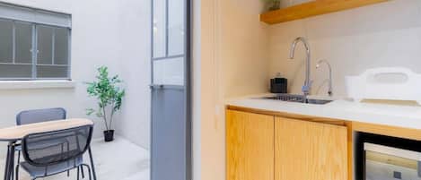 Eine kleine Küche mit integriertem Backofen, Spüle und Holzschrank.