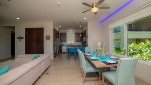Una cocina moderna con comedor, ventilador de techo y vistas a zonas verdes.