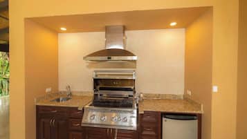 A compact kitchen with a built-in oven, a stainless steel range hood, and a dishwasher.