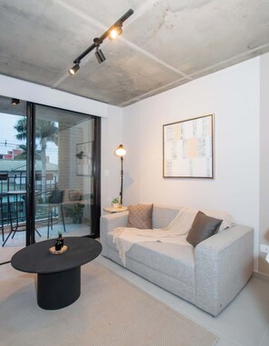 Ein modernes Wohnzimmer mit einer Couch, einem Couchtisch und einer Stehlampe.