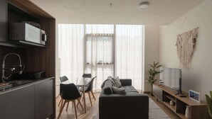 A modern living room with a sofa, TV, and dining area. - Furnished 2 Bedroom Apartment in Mexico City (Ciudad de México)