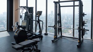 A gym with exercise equipment and a city view through large windows. - Furnished 2 Bedroom Apartment in Mexico City (Ciudad de México)