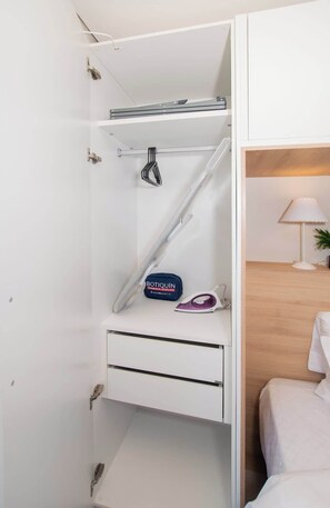 A white wardrobe with a hanging rack, a shelf, and a drawer. - Lovely City View Apt in Perfect Location (Asunción)