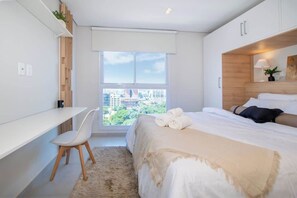 Une chambre à coucher moderne avec un lit, un bureau et une chaise.