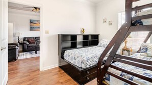 Ein Schlafzimmer mit Etagenbett, Schreibtisch, Stuhl und einer Couch.