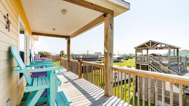 Eine Holzterrasse mit überdachtem Bereich, einem Pavillon und Blick auf eine Wohngegend.