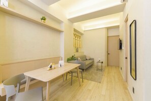 A modern living room with a sofa, a dining table with chairs, and a small plant on a shelf. - HOM 2B Capitalia Palacio Polanco 2BR Prime (Ciudad de México)