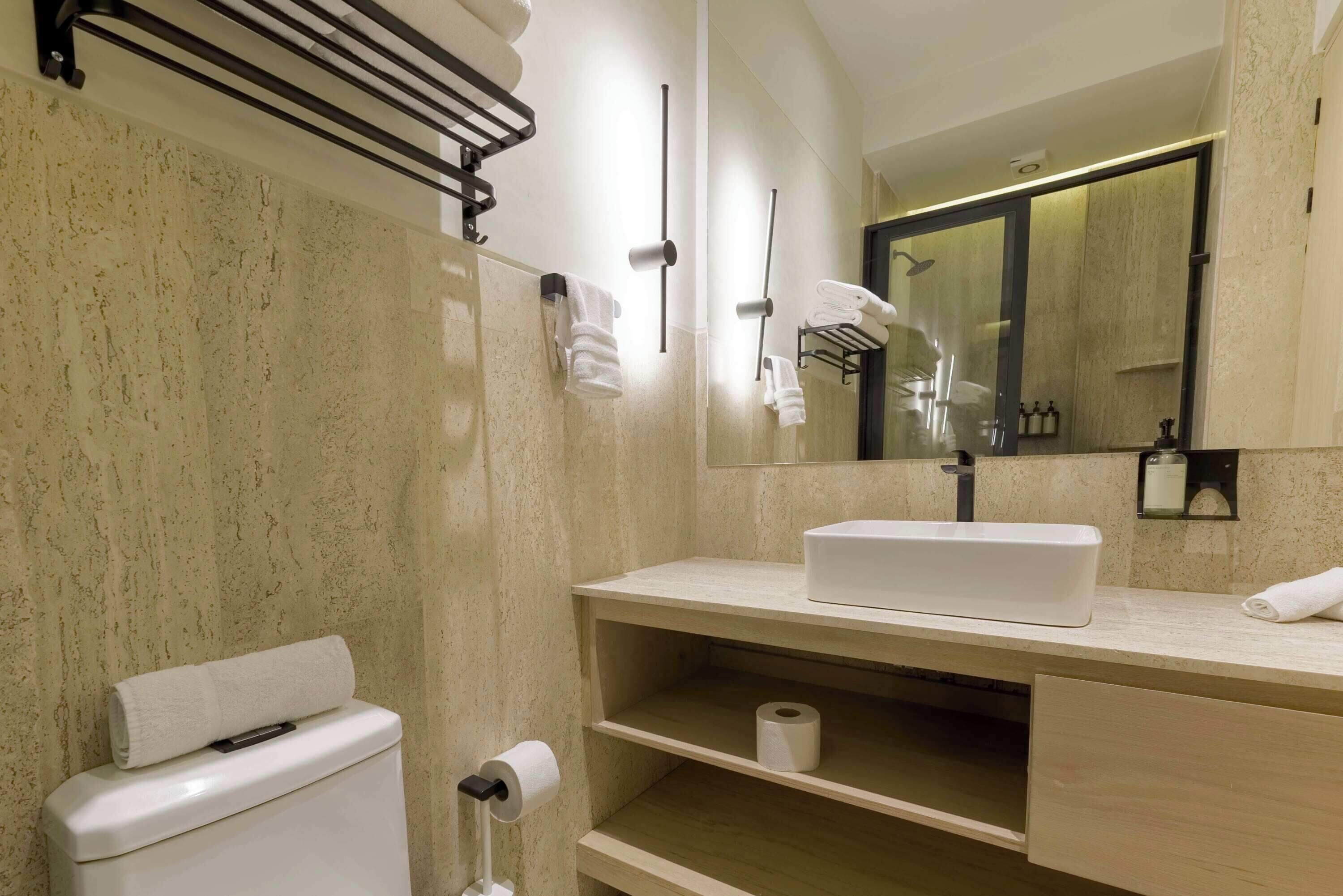 Une salle de bain moderne avec des toilettes, un lavabo et un miroir.