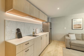 A modern kitchen with a countertop, sink, and stainless steel refrigerator. - Modern King Studio in Central Roma Norte (Ciudad de México)