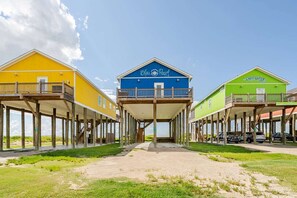 A beachfront property with three buildings, each with a balcony and a wooden deck. - Beachfront, Views, 3bdr 2bth - The Bleu Pearl (Bolivar Peninsula)