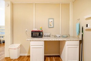 A compact kitchenette with a microwave, coffee maker, and a small trash bin. - 3 King Suites,  15 Guests - Sunzout (Bolivar Peninsula)