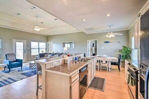 A spacious kitchen with a central island, a dining area with a table and chairs, a seating area with a sofa, and a ceiling fan. - Family Retreat, Hangout Garage & Fire Pit, 3Bd 2Bth (Bolivar Peninsula)