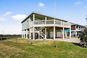 A two-story building with a balcony, a flagpole, and a flag.