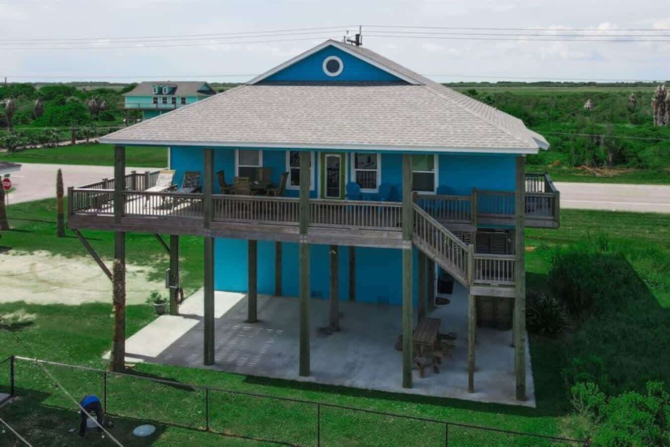 A two-story house with a balcony, a covered porch, and a view of the surrounding landscape.