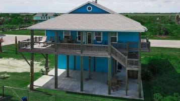 A two-story house with a balcony, a covered porch, and a view of the surrounding landscape.