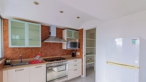 A kitchen with a stove, microwave, and white refrigerator. - Capitalia  Bright & Cozy Family Apt in Santa Fe (Ciudad de México)