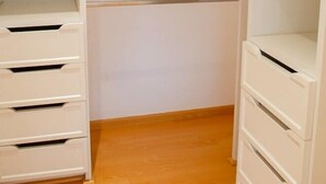 A walk-in closet with open shelves and drawers, wooden flooring, and a closet rod. - Capitalia  Bright & Cozy Family Apt in Santa Fe (Ciudad de México)