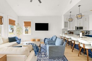 A modern living room with a sofa, a coffee table, and a patterned rug. - Golf Cart, Elevator, Stylish, 12 guests - LaPerla (Bolivar Peninsula)