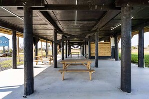 An outdoor covered pavilion with picnic tables, wooden beams, and concrete flooring. - Unit B of Crystal Beach's Premier Triplex 2Bd 1Bth (Bolivar Peninsula)
