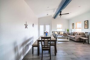 A spacious living area with a dining table, sofas, and a ceiling fan. - Unit B of Crystal Beach's Premier Triplex 2Bd 1Bth (Bolivar Peninsula)