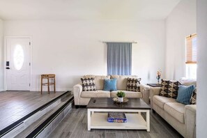 A living room with a sofa set, a coffee table, and a small side table. - Unit A of Crystal Beach's Premier Triplex 2Bd 1Bth (Bolivar Peninsula)